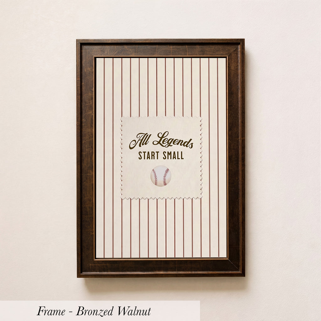 A framed picture of a baseball with the text "All Legends Start Small" on it, hanging on a wall.