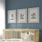 A nursery room with a wooden crib and three framed pictures of teddy bears on the wall.