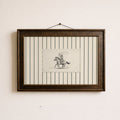 a framed artwork of a cowboy riding a horse, with a black and white illustration of the cowboy and the horse.