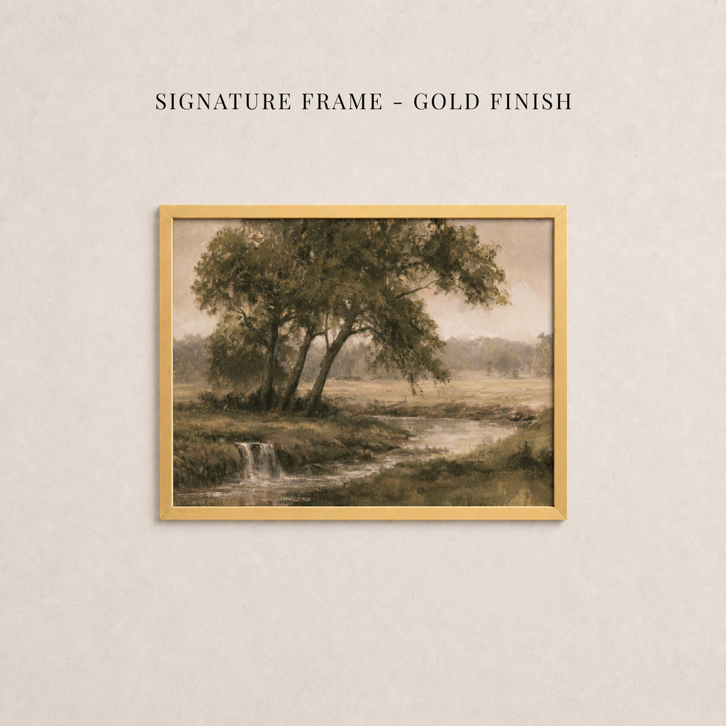 The image is a painting of a serene landscape with a river, trees, and a waterfall. The painting is framed in a gold finish, and the text above the painting reads "SIGNATURE FRAME - GOLD FINISH".
