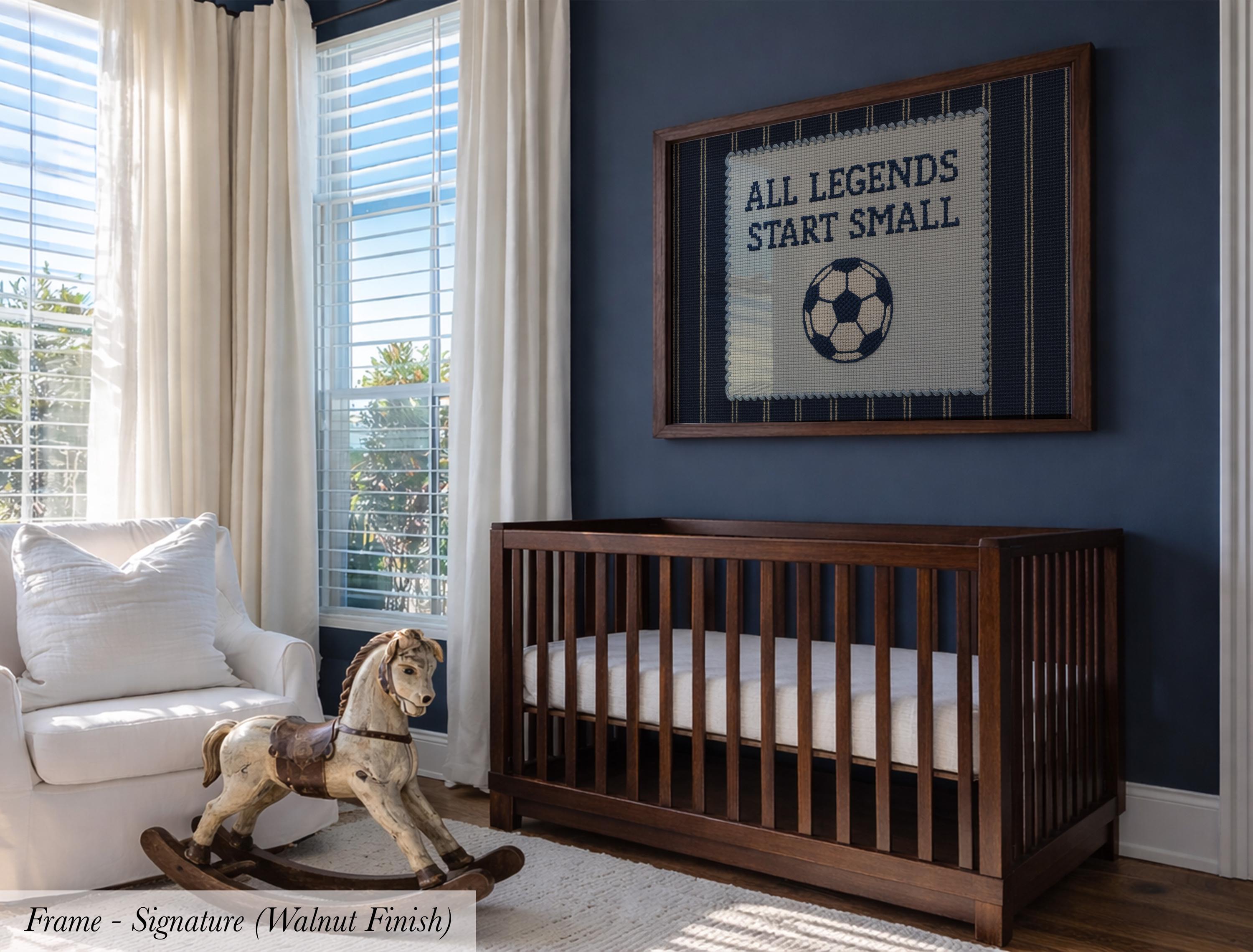 A nursery room with a wooden crib, a rocking horse, and a framed sign with the text "ALL LEGENDS START SMALL" on the wall.