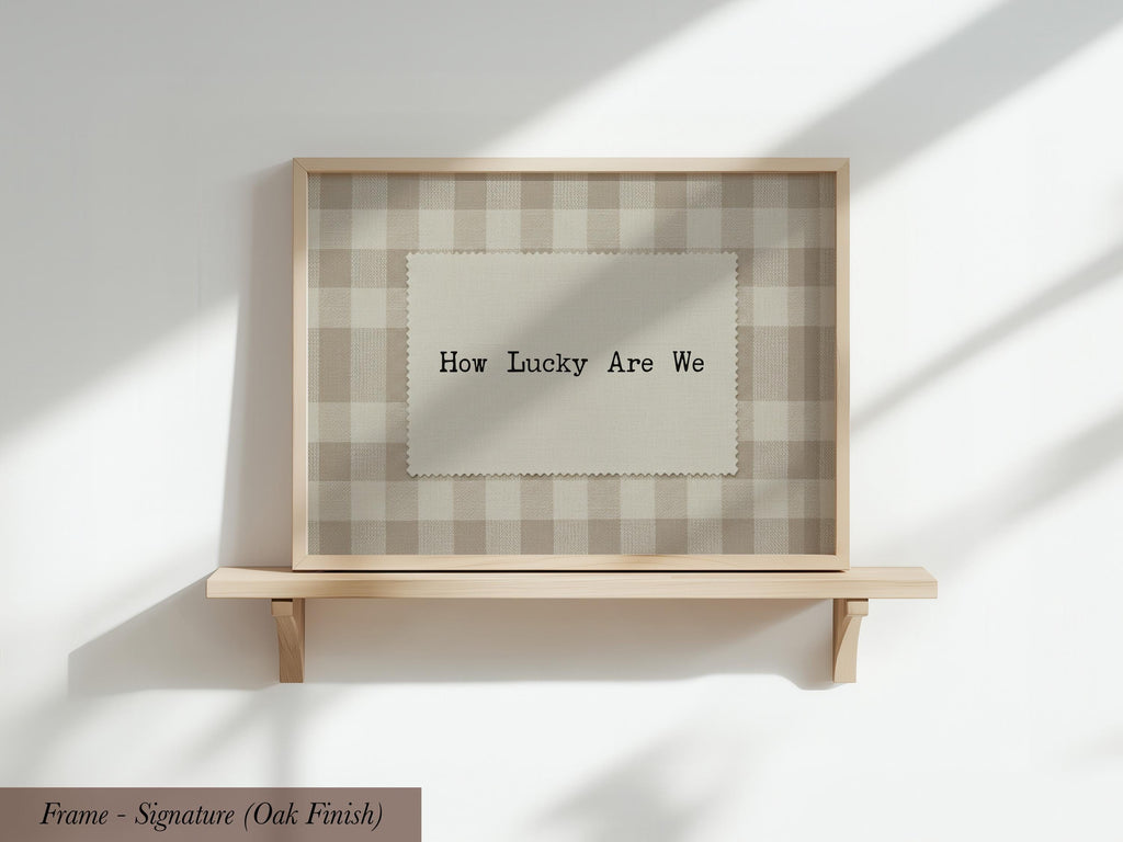 A wooden shelf with a framed picture on it, displaying the text "How Lucky Are We" in a checkered pattern.