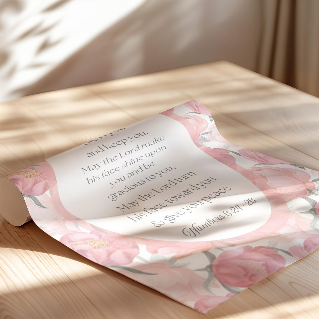 a floral-patterned paper with a religious text on it, placed on a wooden surface.