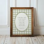 A framed print with a green and white checkered pattern and a Bible verse from Psalm 17:73 is displayed on a wooden floor against a white wall.