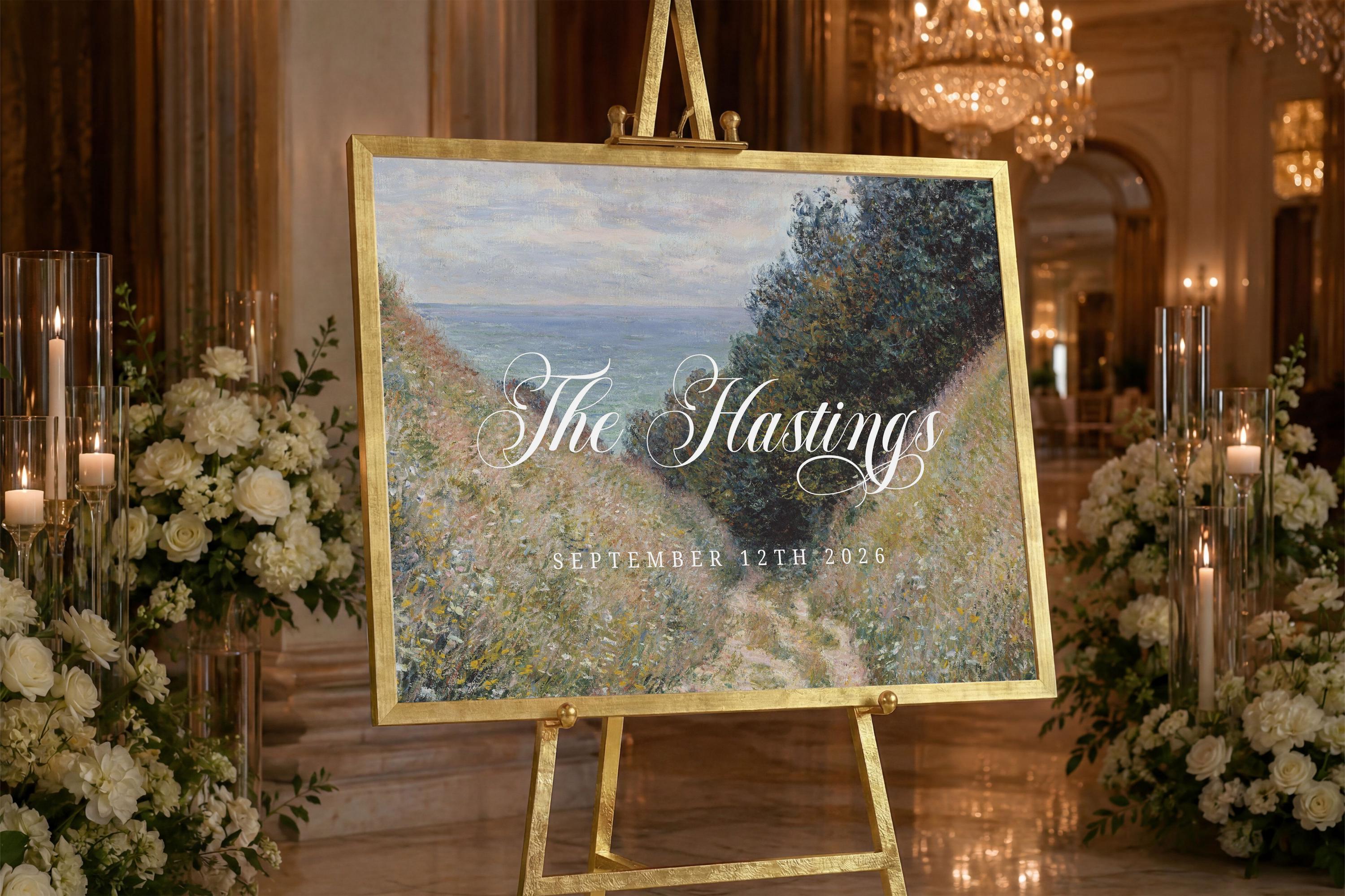 a large painting of a scenic landscape, with the text "The Hastings" and "SEPTEMBER 12TH 2026" displayed on it. The painting is mounted on a gold easel in a room with a chandelier and floral arrangements.