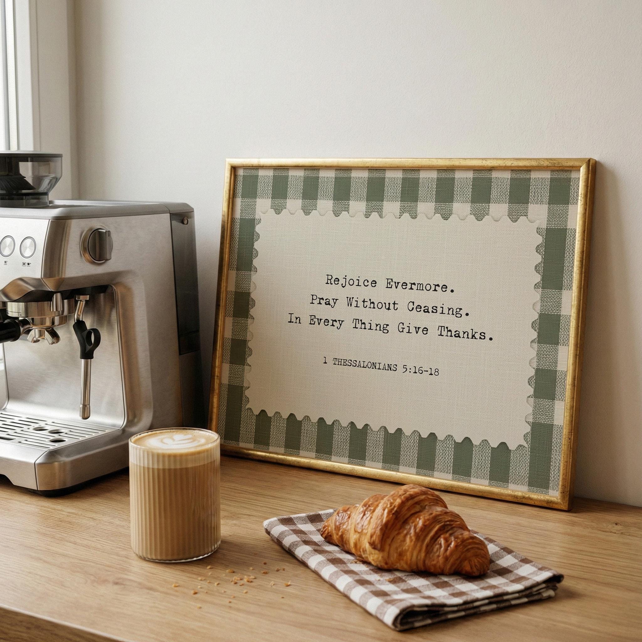 a framed inspirational quote, a croissant, and a cup of coffee on a wooden table.