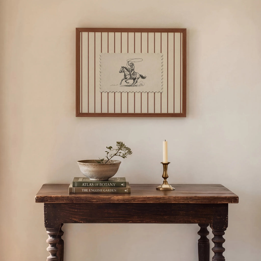 a cozy corner of a room with a wooden table, a framed picture, a candle, and a bowl of flowers.