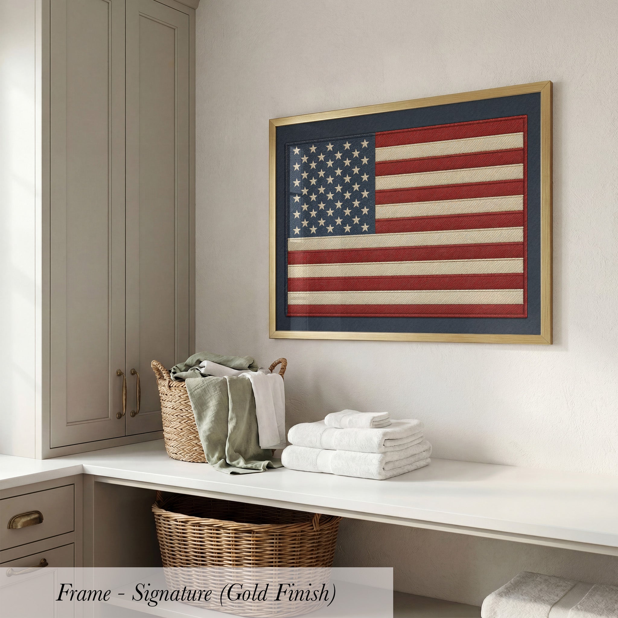 a framed American flag hanging on a wall above a white countertop with folded towels and a wicker basket.