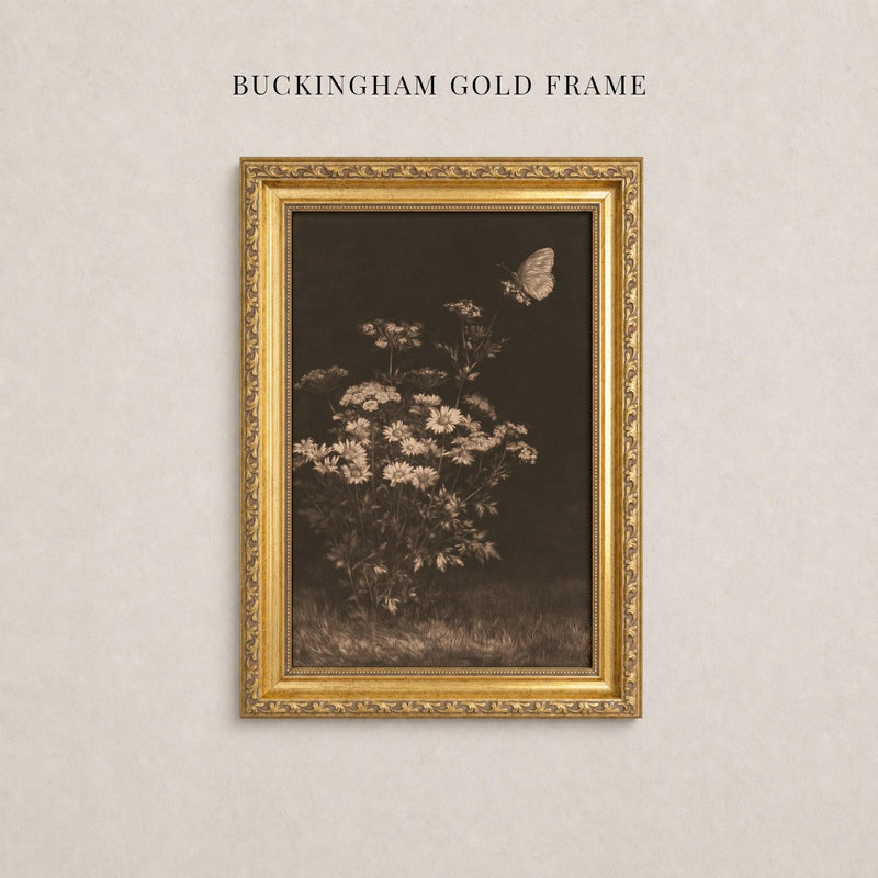 A gold-framed painting of a flower is hanging on a wall.