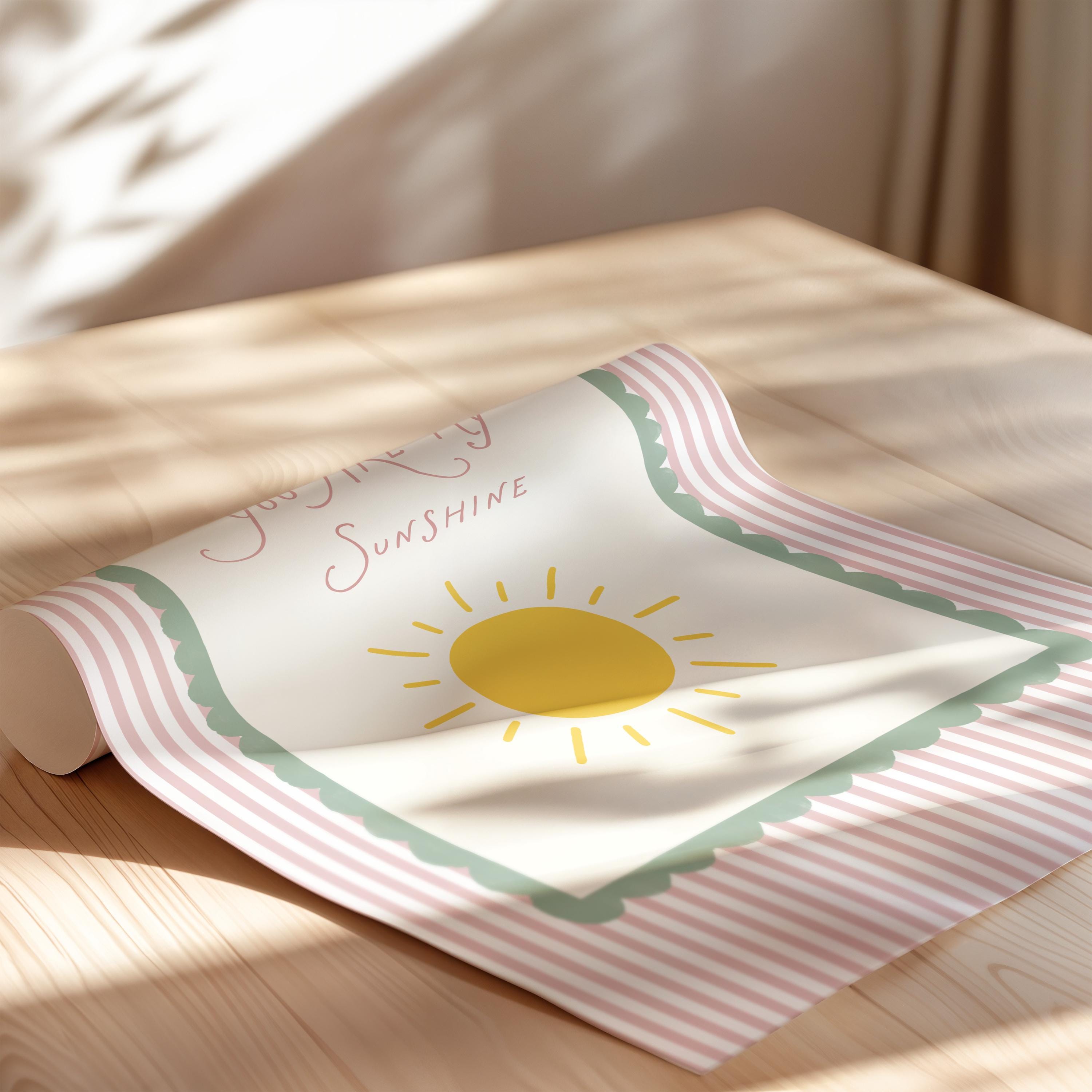 A colorful poster with a sun design and the text "Joyful Sunshine" is displayed on a wooden surface.