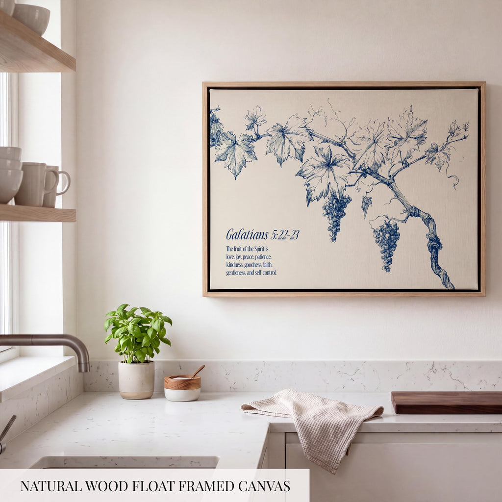 a kitchen counter with a potted plant, a wooden cutting board, and a framed canvas depicting a blue and white illustration of grapes and leaves.