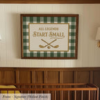A framed sign with the text "ALL LEGENDS START SMALL" is hanging on a wall above a wooden crib.