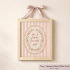 A framed picture with a pink ribbon and lace border, featuring a decorative floral design and the text "Thank heaven for little girls".