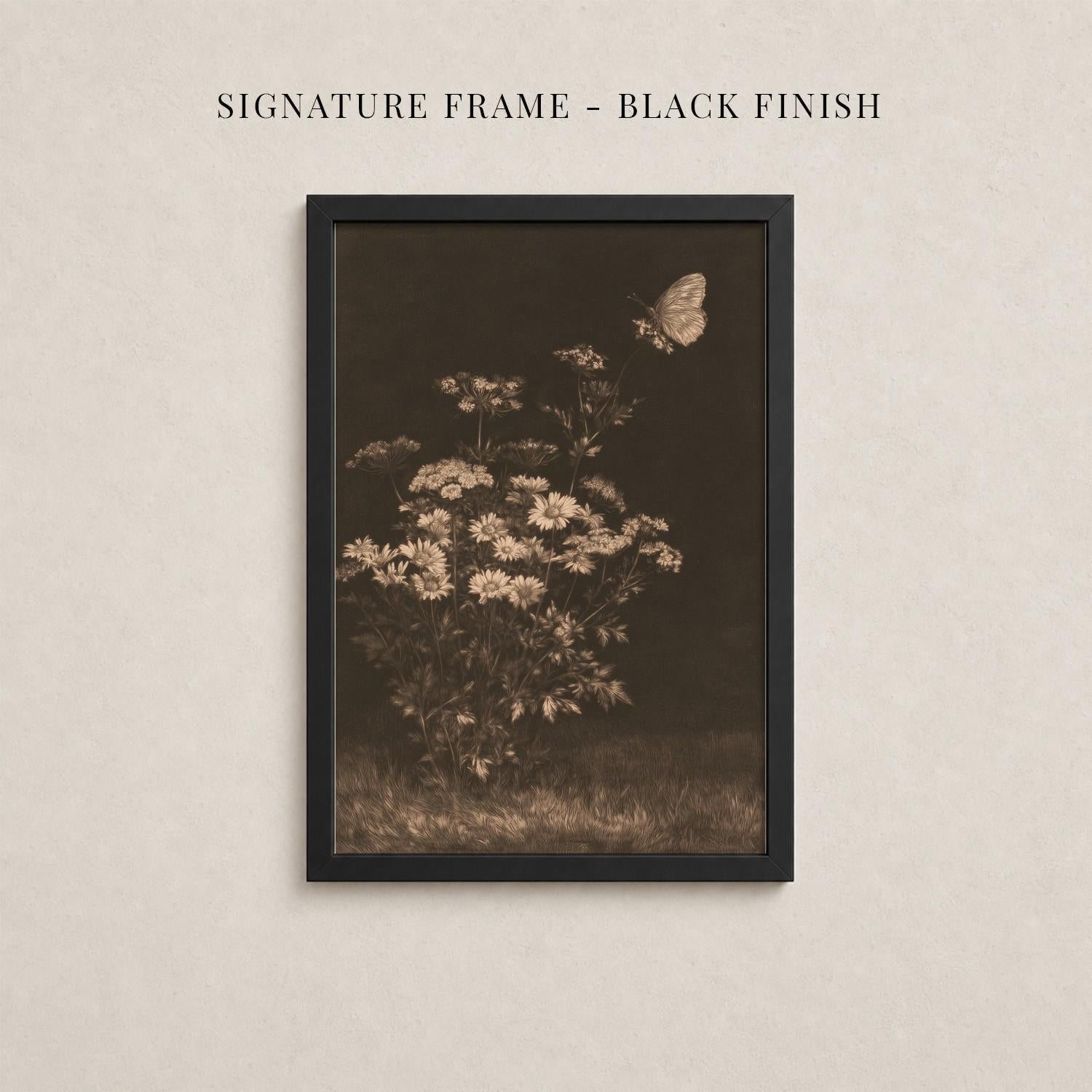 The image is a black and white photograph of a flower with a butterfly in flight, displayed in a black frame against a beige background.