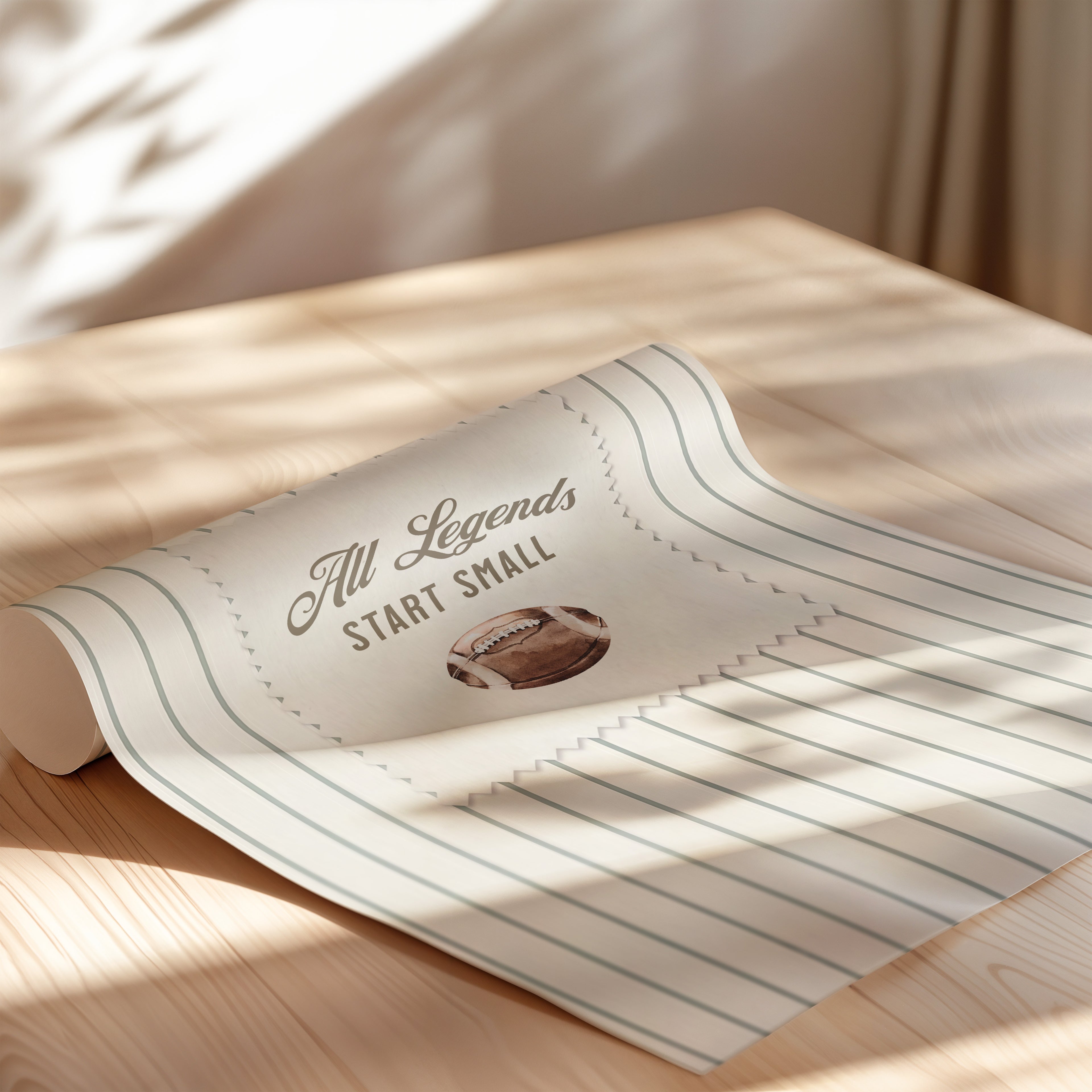 A roll of paper with the text "All Legends Start Small" printed on it, along with an image of a football.