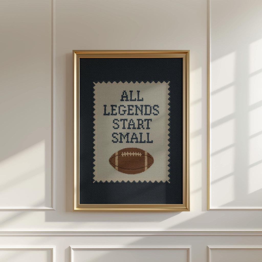 a framed cross-stitch design with the text "ALL LEGENDS START SMALL" printed on it.