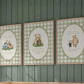 three framed canvas prints of Winnie the Pooh illustrations, hanging on a wall above a wooden crib.