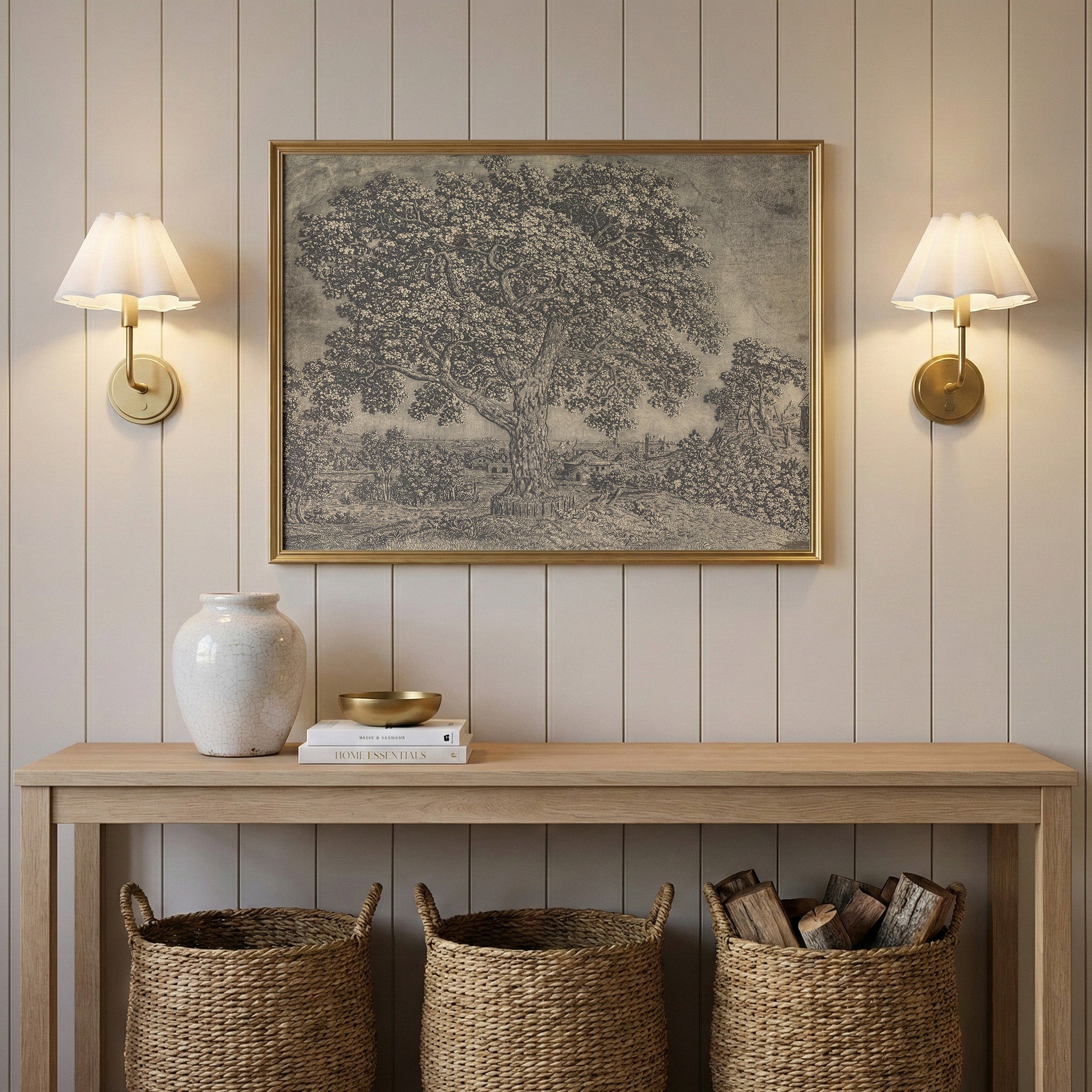 a wooden console table with a framed picture of a tree hanging above it, flanked by two wall sconces. The table also has a white vase, a stack of books, and three woven baskets.
