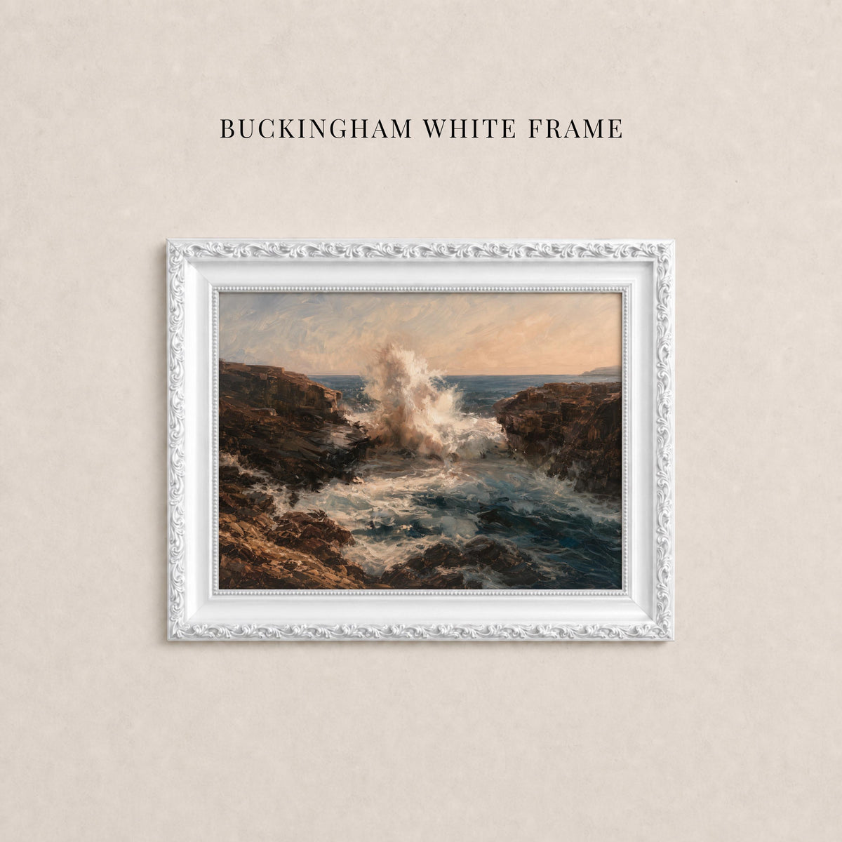A white framed painting depicting a rocky coastline with crashing waves, hanging on a beige wall.