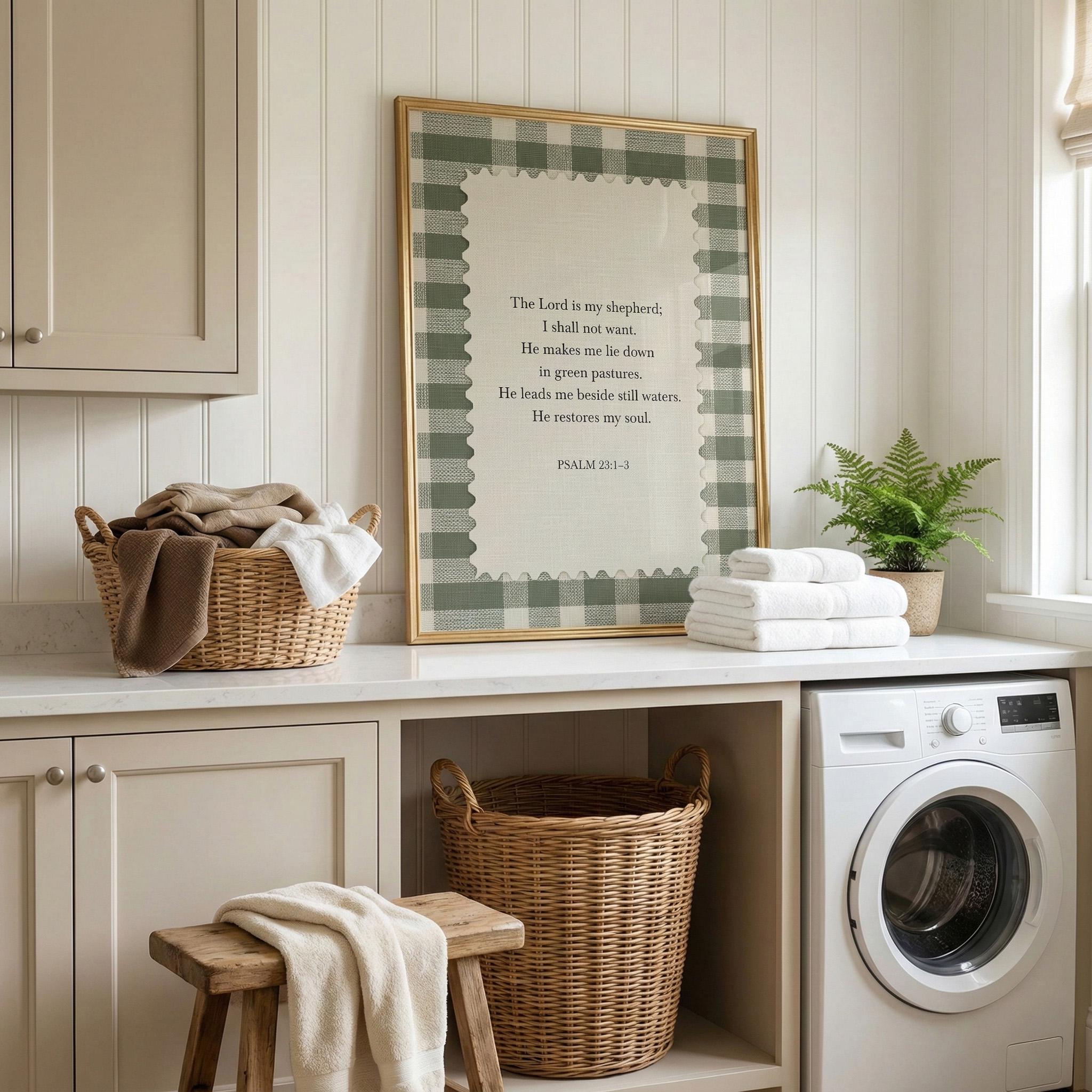 a laundry room with a framed Bible verse, a basket of towels, a washing machine, and a wooden stool.