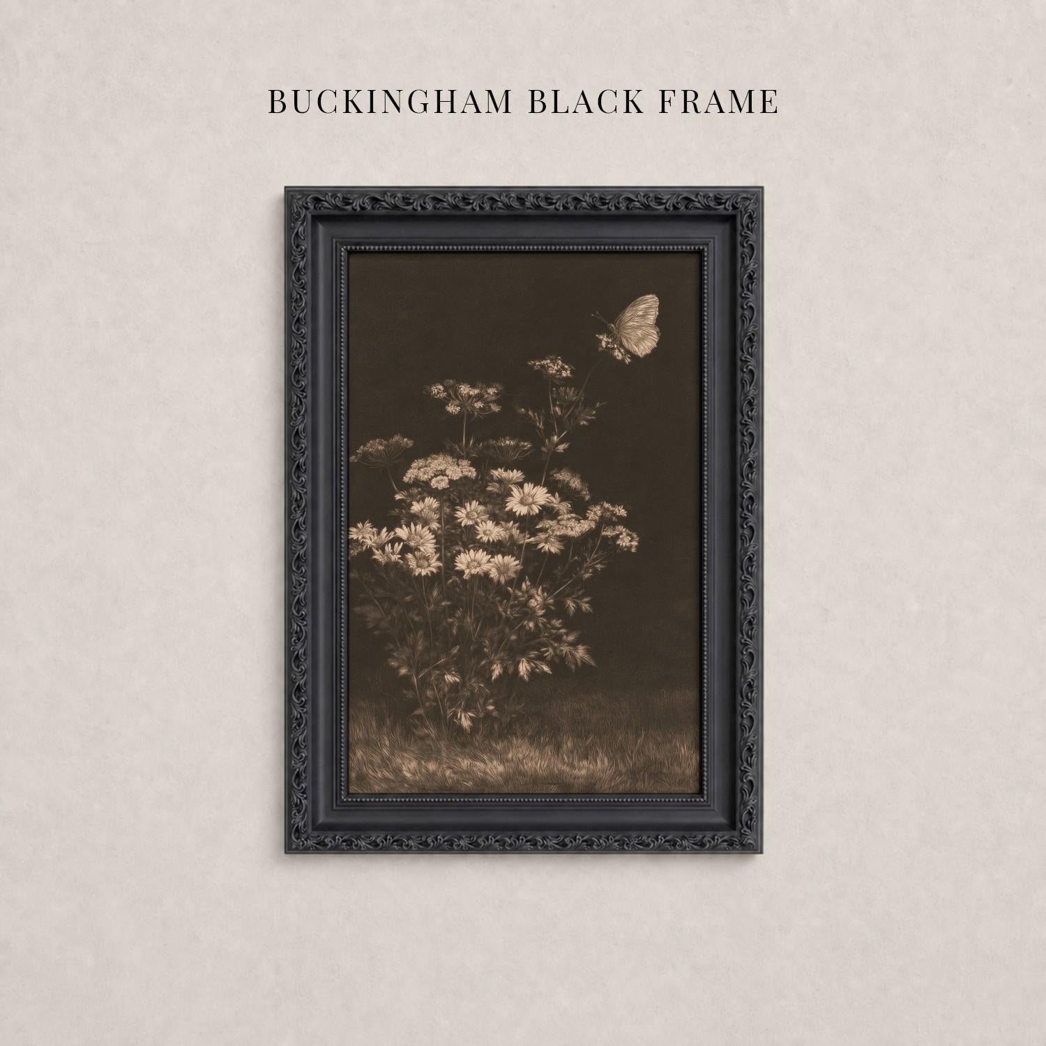 A black framed photograph of a flower arrangement with a butterfly in flight, hanging on a wall.