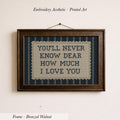 a framed embroidered piece of art with the text "YOU'LL NEVER KNOW DEAR HOW MUCH I LOVE YOU" on it.