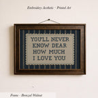 a framed embroidered piece of art with the text "YOU'LL NEVER KNOW DEAR HOW MUCH I LOVE YOU" on it.