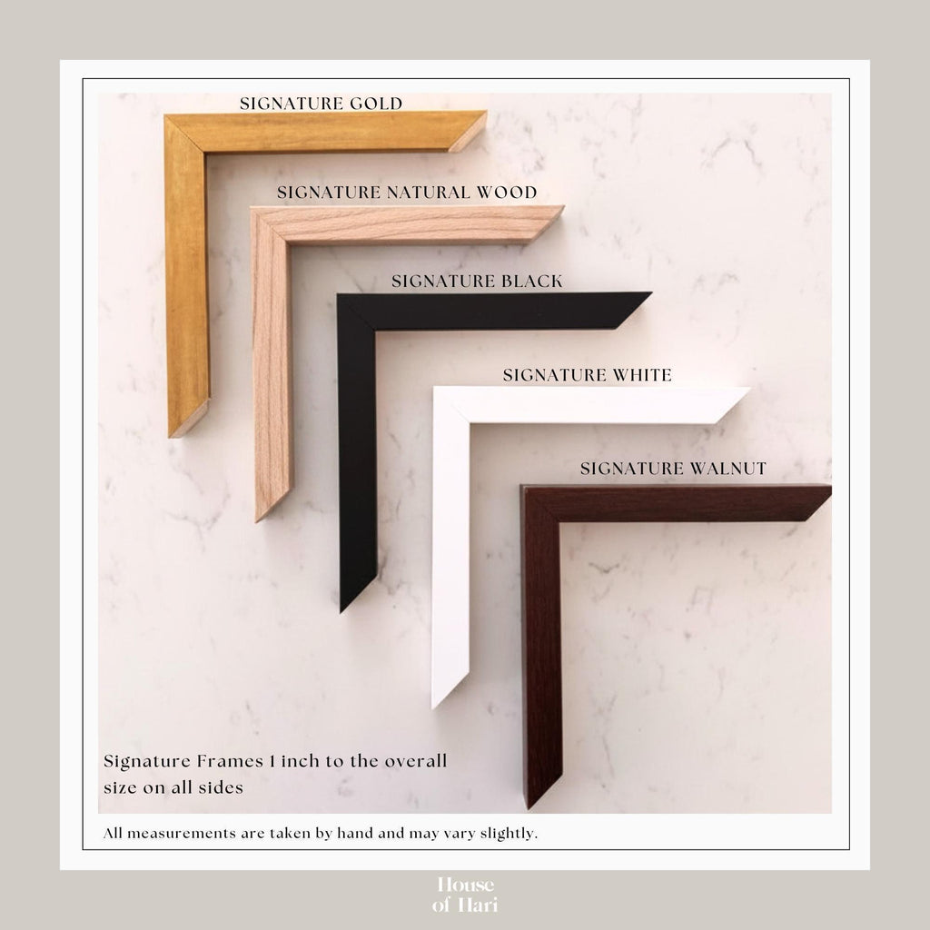 a collection of five signature frames in various colors and materials, including gold, natural wood, black, white, and walnut. The frames are arranged in a row, with the gold frame being the largest and the walnut frame being the smallest. The image also includes a caption that states all measurements are taken by hand and may vary slightly.