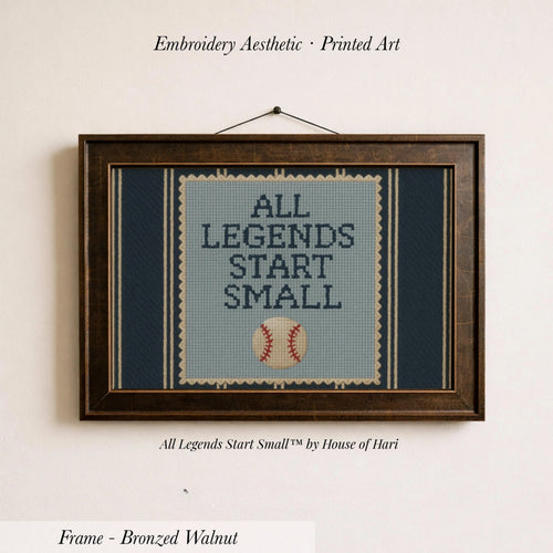 a framed cross-stitch design with the text "ALL LEGENDS START SMALL" and a baseball graphic.