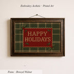 A framed embroidered design with the text "HAPPY HOLIDAYS" on a green and red plaid background.