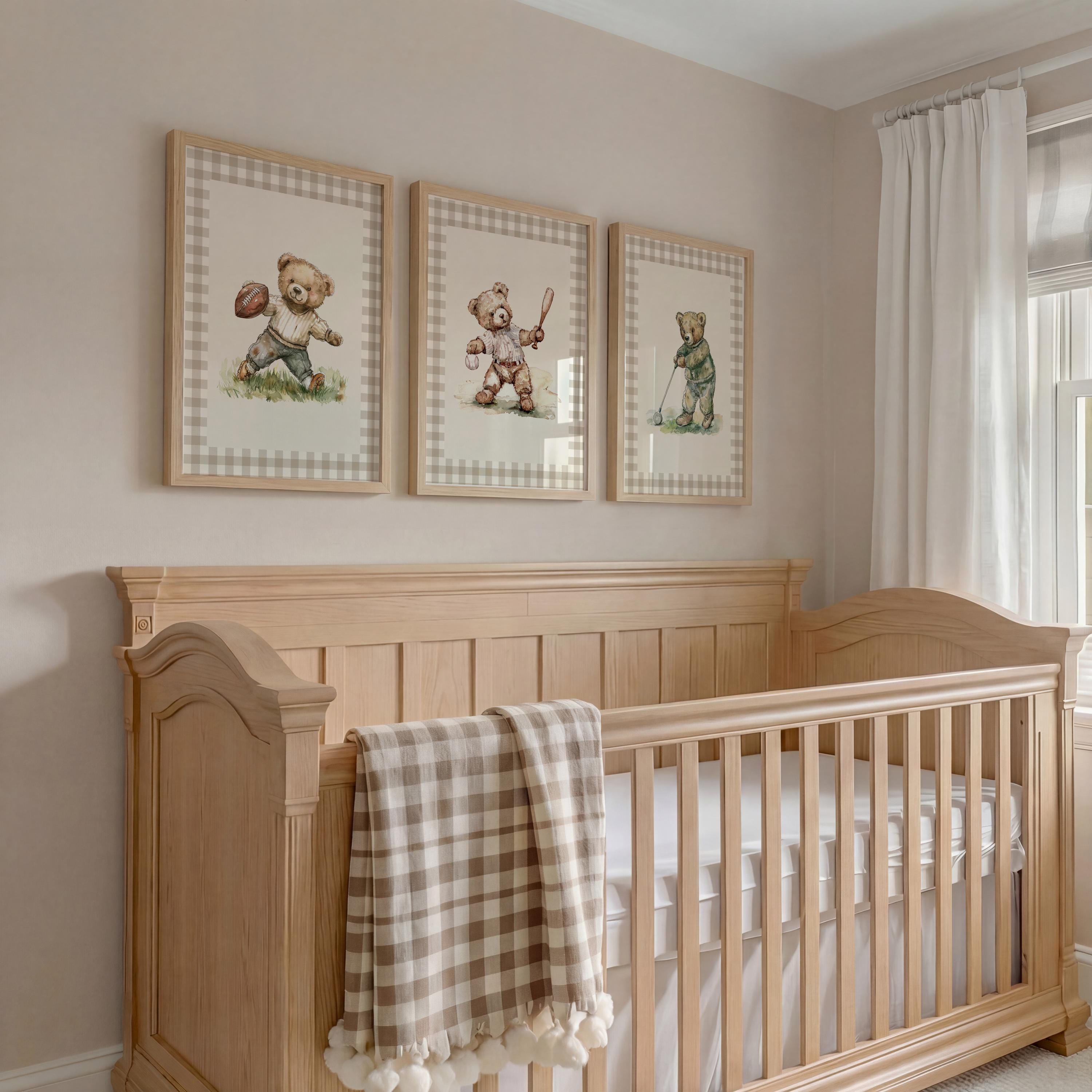 A wooden crib with a blanket and three framed teddy bear illustrations on the wall above it.