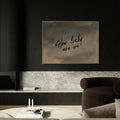 a modern living room with a dark color scheme and a large framed text on the wall that reads "How lucky are we".