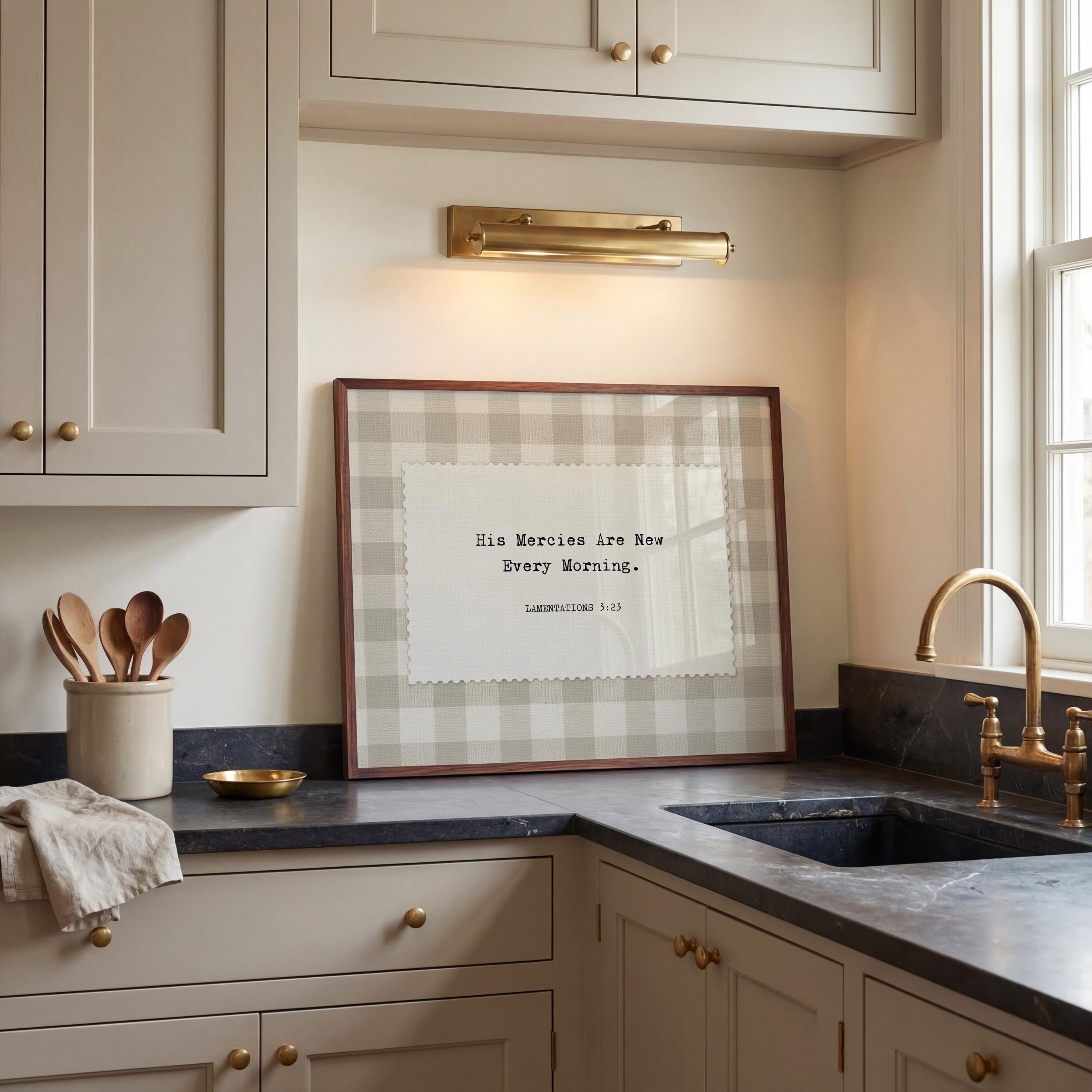 a kitchen counter with a framed quote, a sink, and various kitchen utensils such as spoons.