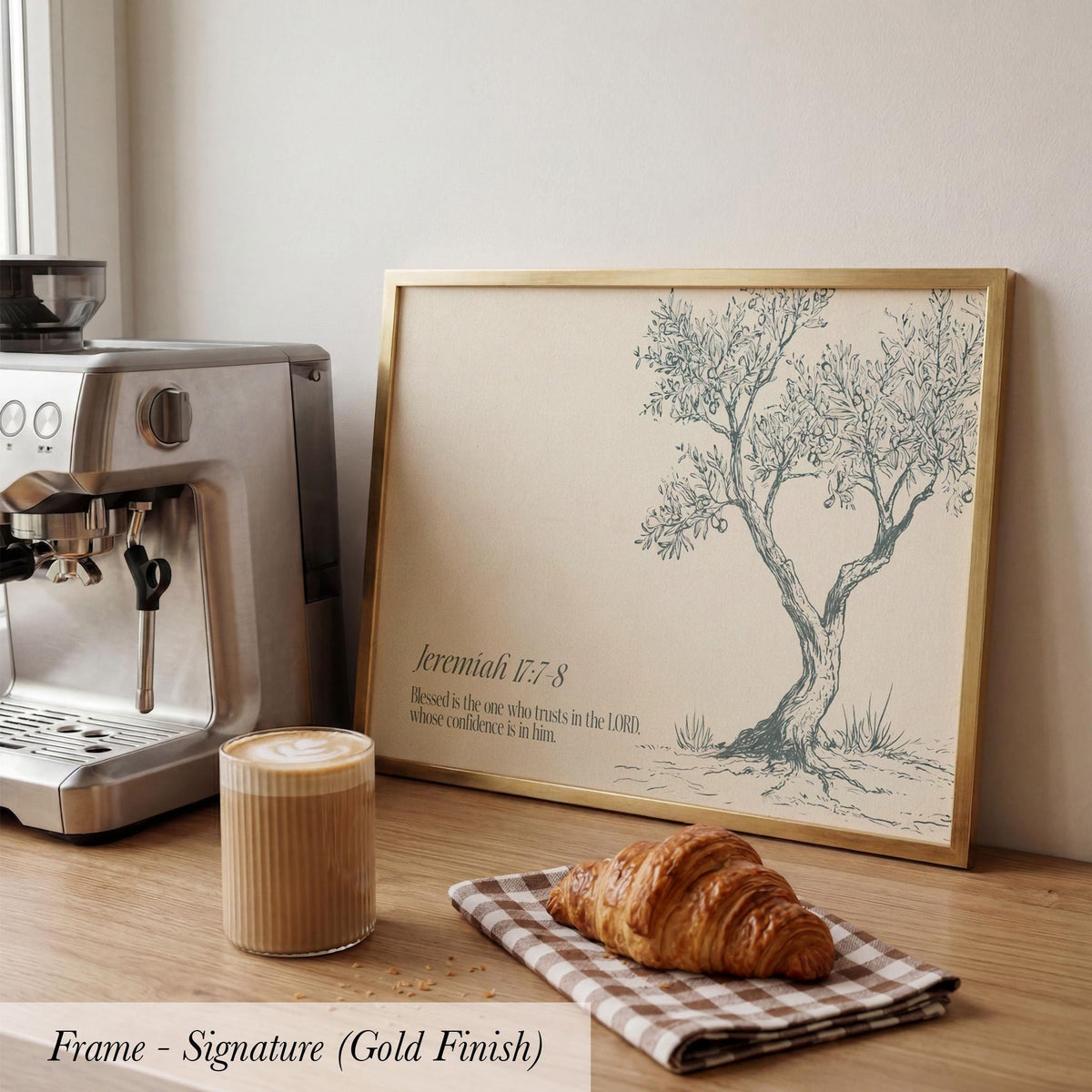 a framed illustration of a tree with a caption that reads " Jeremiah 17:7 N. Blessings are the ones who trust in the Lord, who have confidence in Him". The image also includes a croissant and a cup of coffee on a wooden surface.