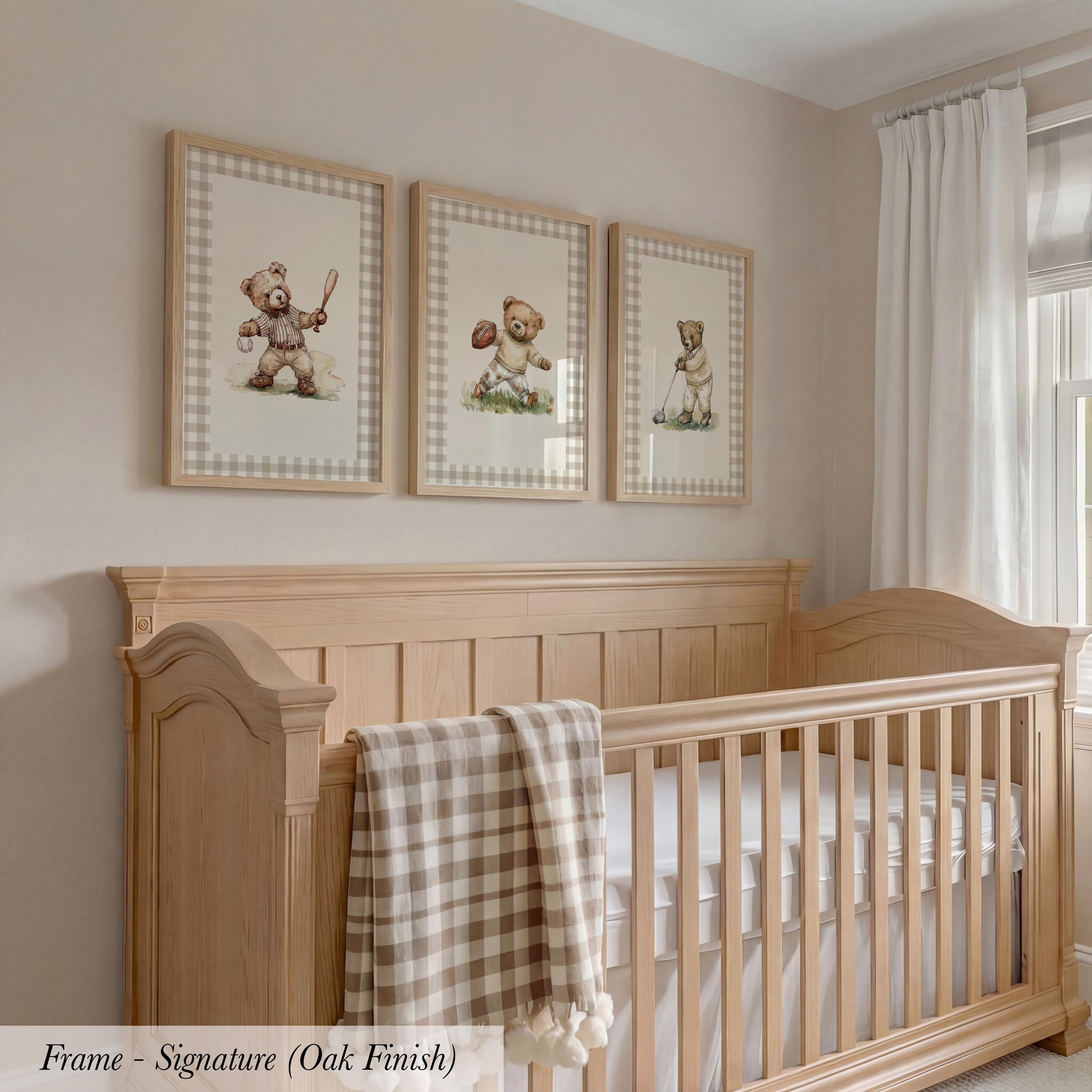 A wooden crib with a checkered blanket and three framed teddy bear illustrations on the wall above it.