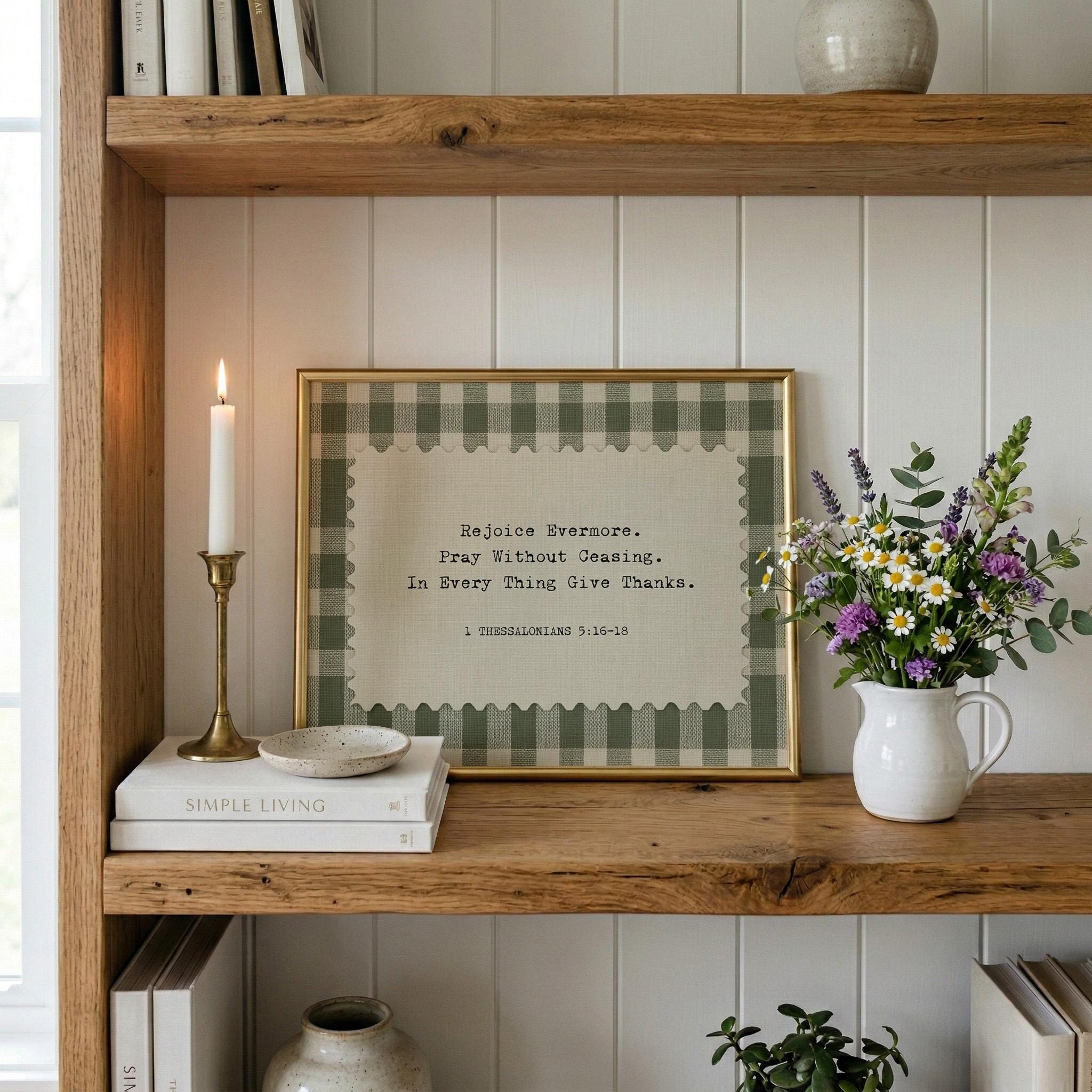 a wooden bookshelf with a framed quote, a white candle, a vase of flowers, and some books.