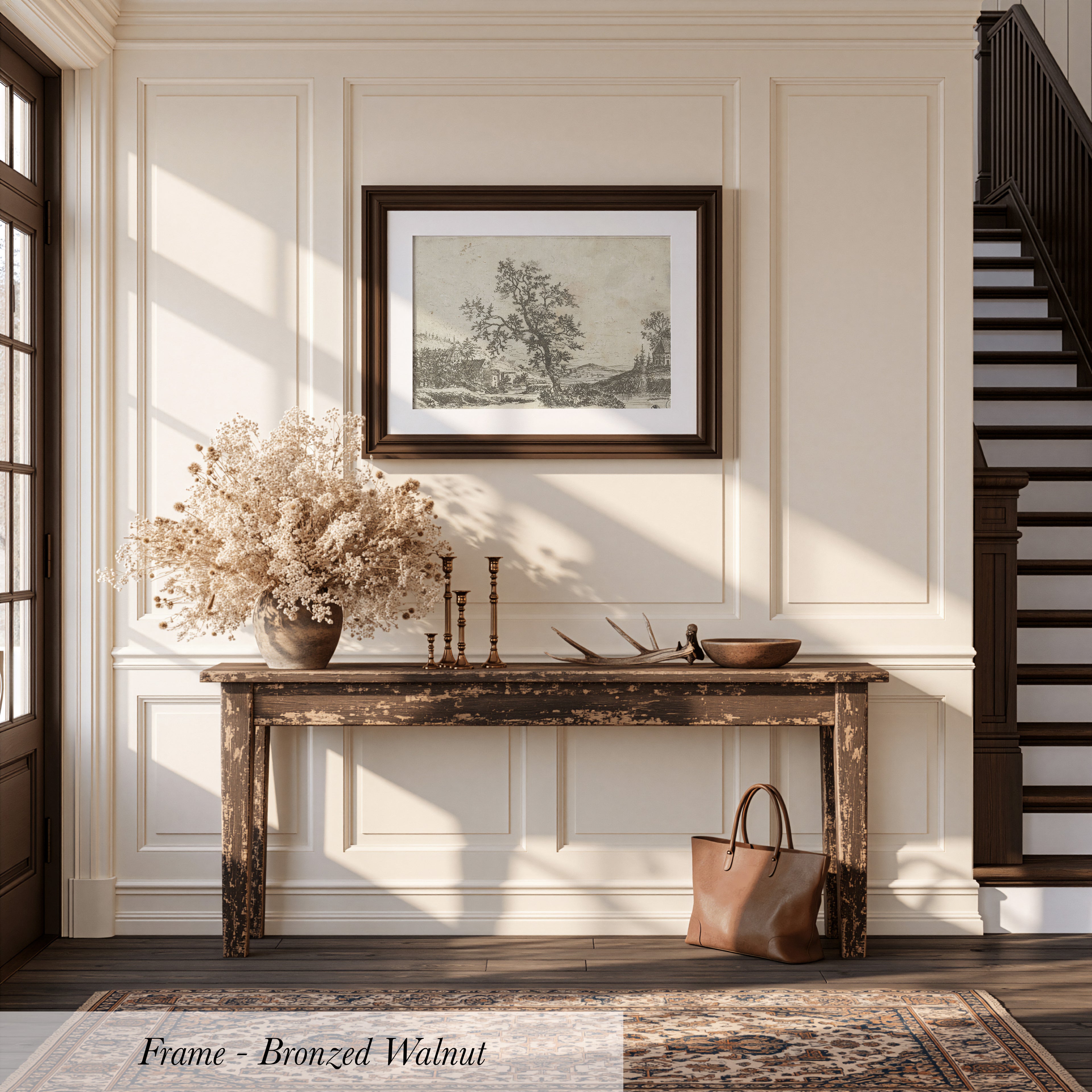 a rustic wooden console table with a vase of dried flowers, a picture frame, and a handbag, set against a backdrop of white walls and a wooden staircase.
