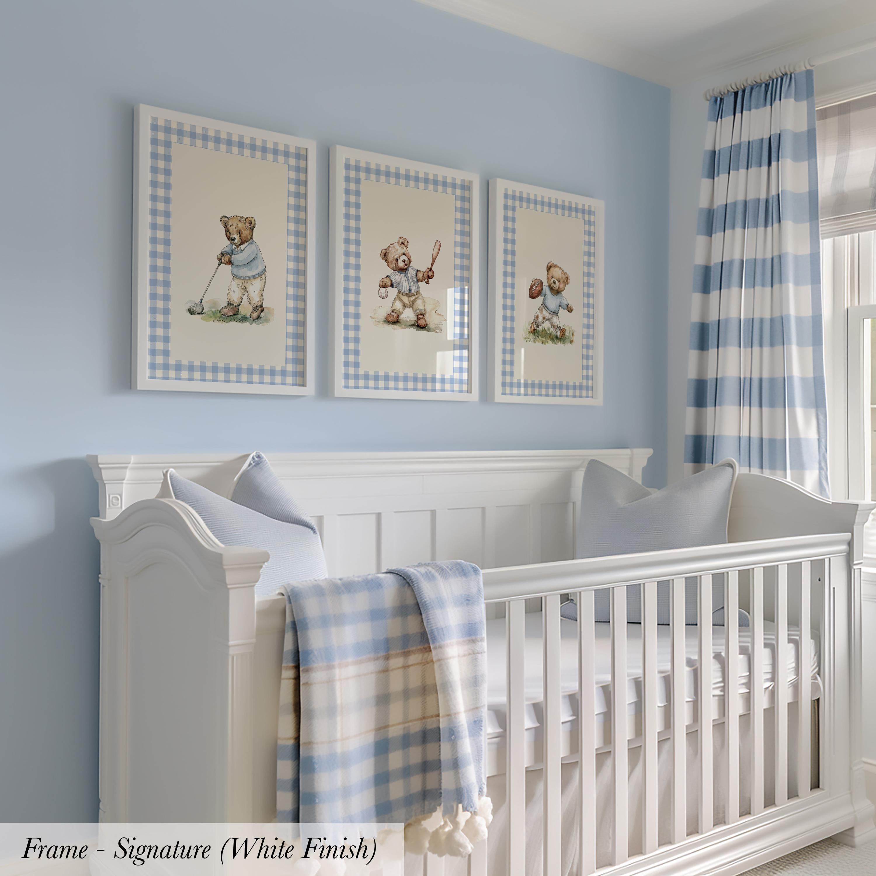 A white crib with three framed pictures of teddy bears above it, set against a light blue wall with a striped curtain.