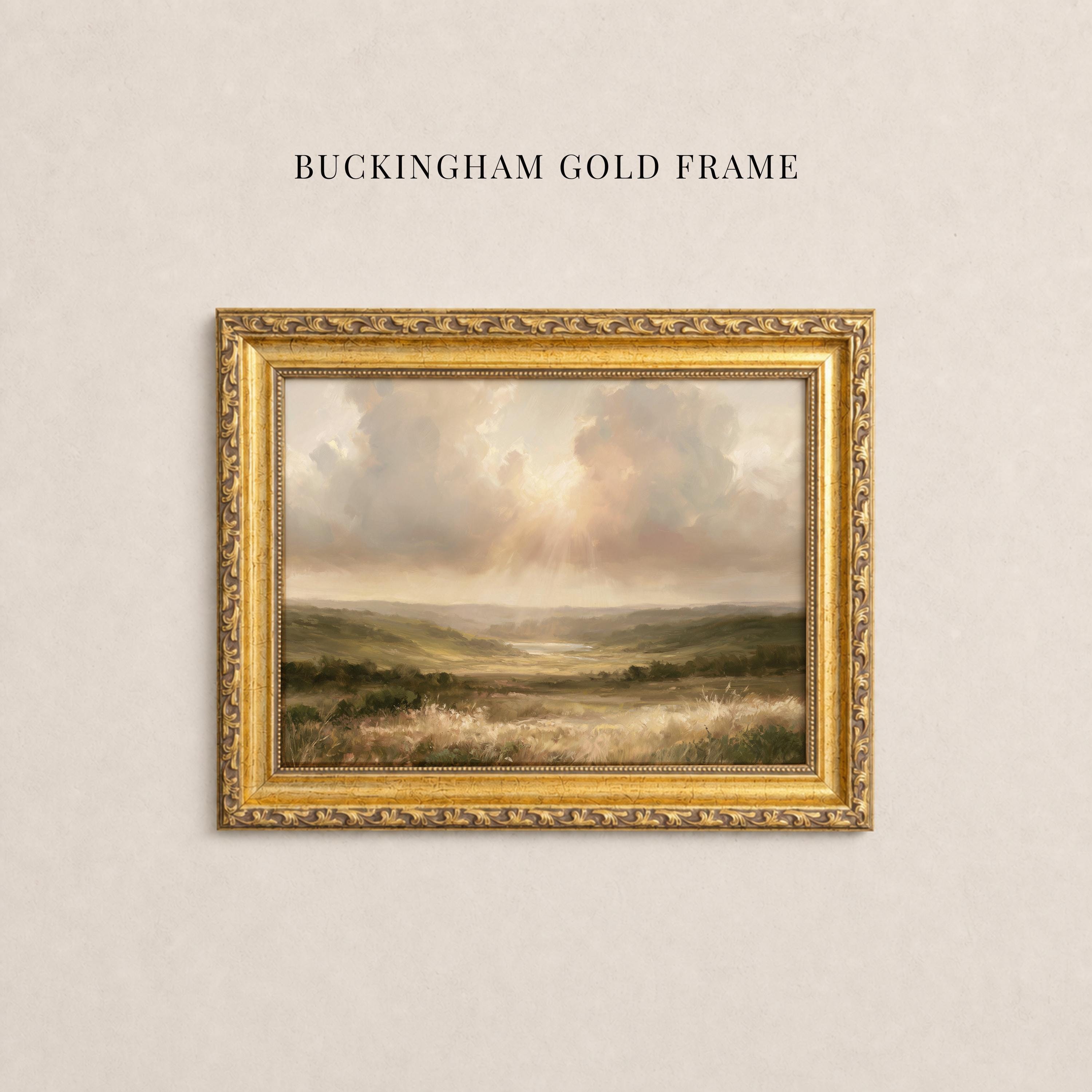 May include: A landscape painting in a decorative gold frame with the text BUCKINGHAM GOLD FRAME above it. The artwork depicts a grassy valley under a cloudy sky with light rays breaking through. The frame features an ornate, textured border.