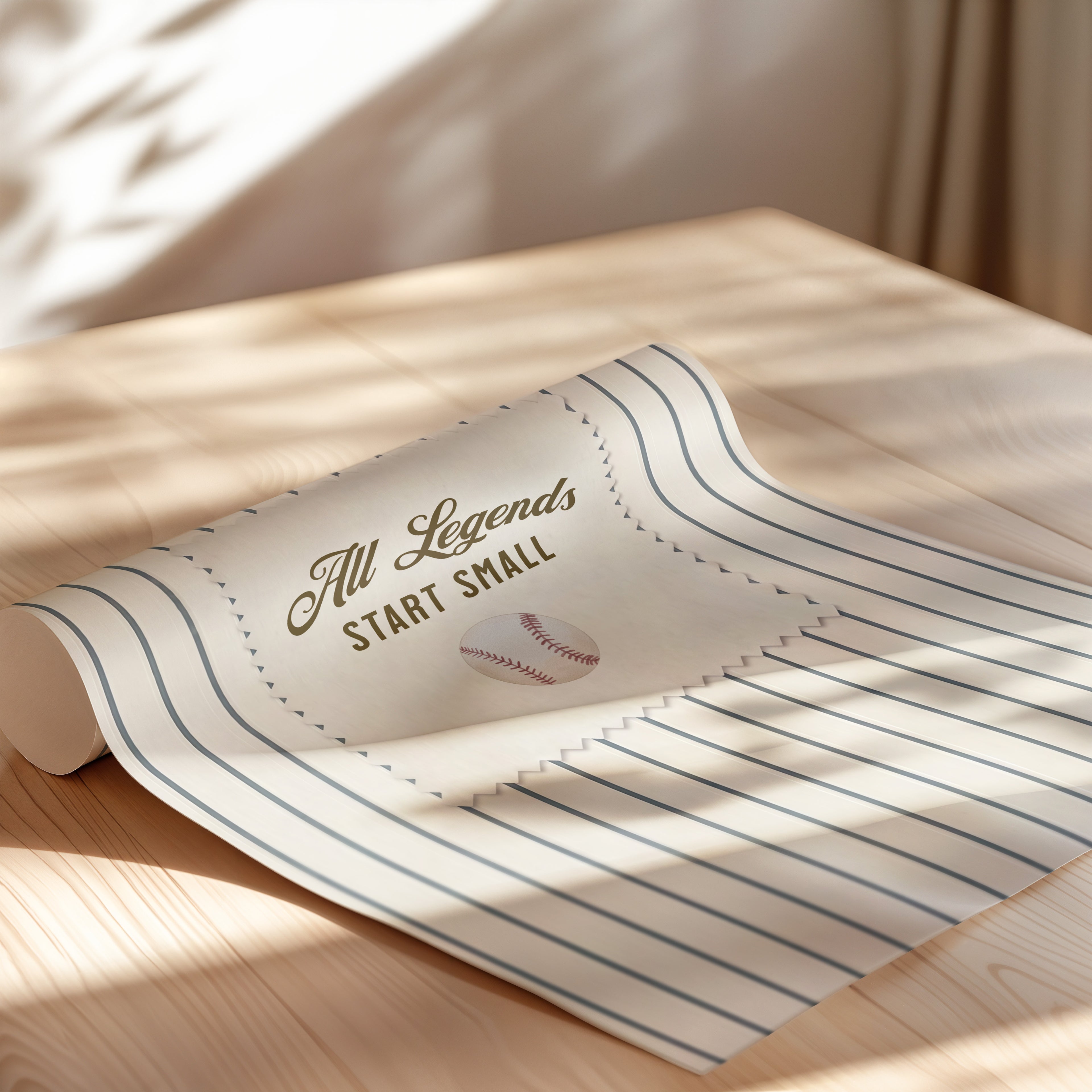 A rolled-up paper with the text "All Legends Start Small" and a baseball graphic on it, placed on a wooden surface.