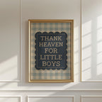 a framed sign with the text "THANK HEAVEN FOR LITTLE BOYS" on it, hanging on a white wall.