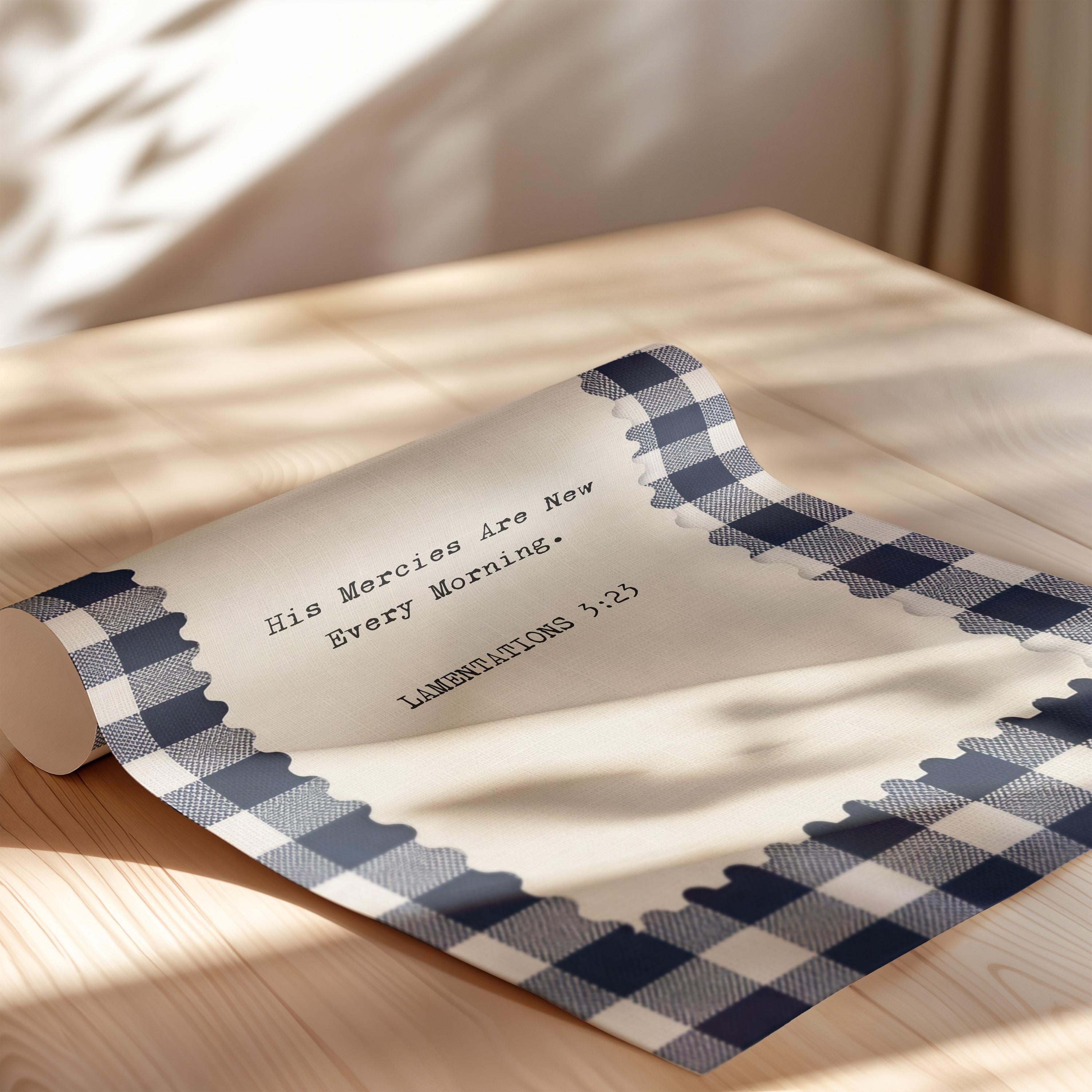 a piece of paper with a blue and white checkered border, placed on a wooden surface. The paper has a message written on it, which reads "His Mercions Are New Every Morning."